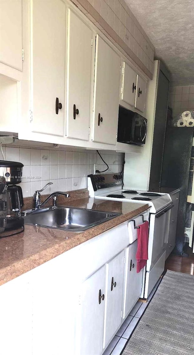 kitchen featuring backsplash, sink, electric stove, and white cabinets