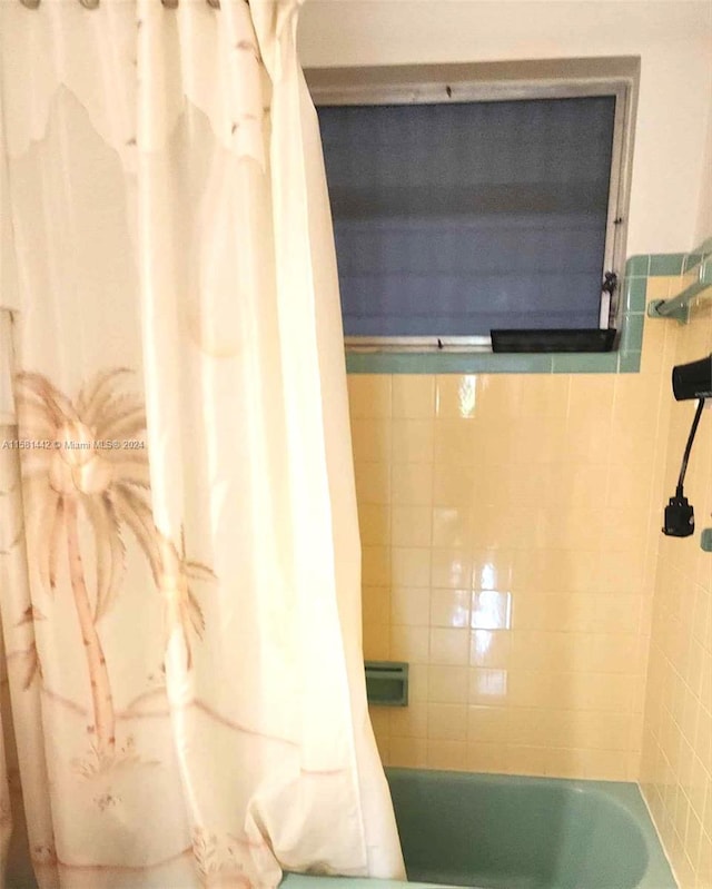 bathroom with shower / bathtub combination with curtain