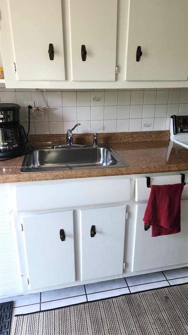 kitchen with white cabinets, sink, tasteful backsplash, and light tile flooring