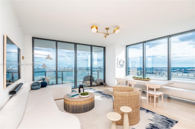 living room featuring a water view, hardwood / wood-style floors, and floor to ceiling windows