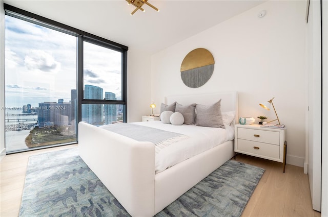 bedroom with light hardwood / wood-style flooring and a wall of windows