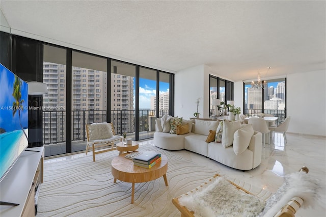 living room with a textured ceiling, a notable chandelier, and a wall of windows