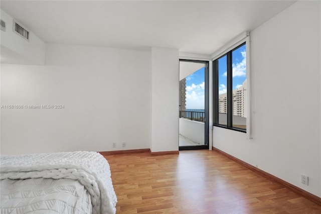 bedroom featuring light hardwood / wood-style flooring and expansive windows