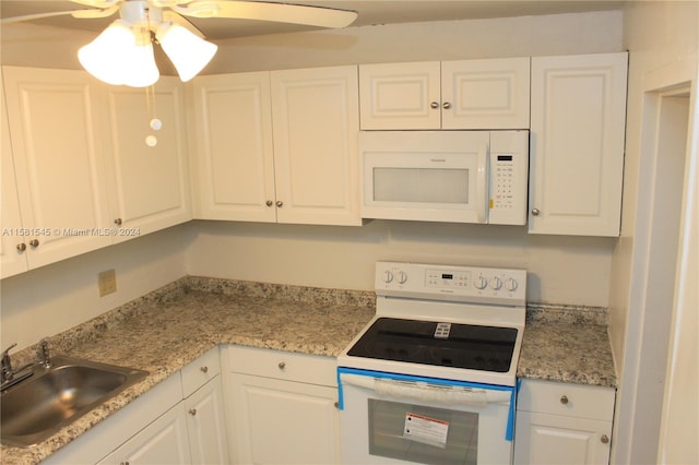 kitchen featuring white cabinetry, sink, and white appliances