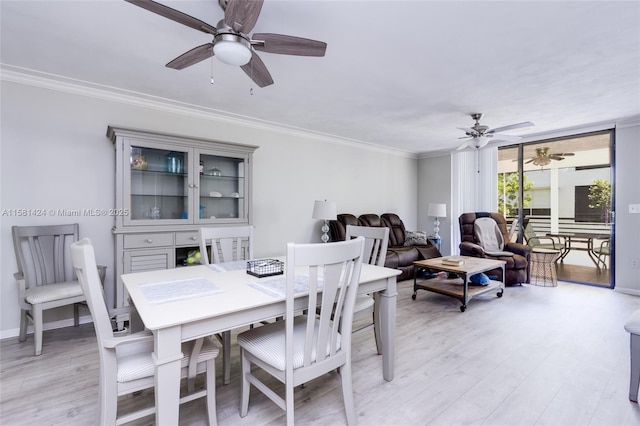 dining area with light wood finished floors, baseboards, and ornamental molding