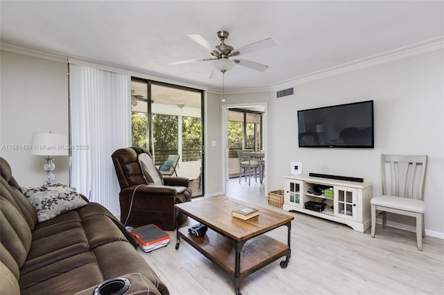 living room featuring light wood finished floors, ornamental molding, and visible vents