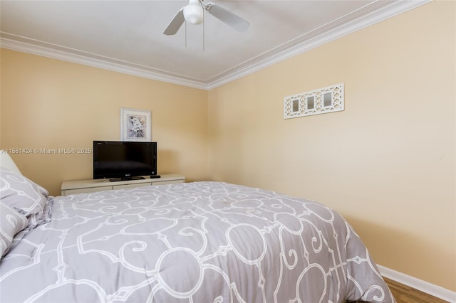 bedroom featuring ornamental molding, wood finished floors, a ceiling fan, and baseboards