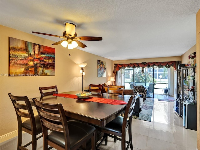 dining space featuring ceiling fan, a textured ceiling, and light tile floors