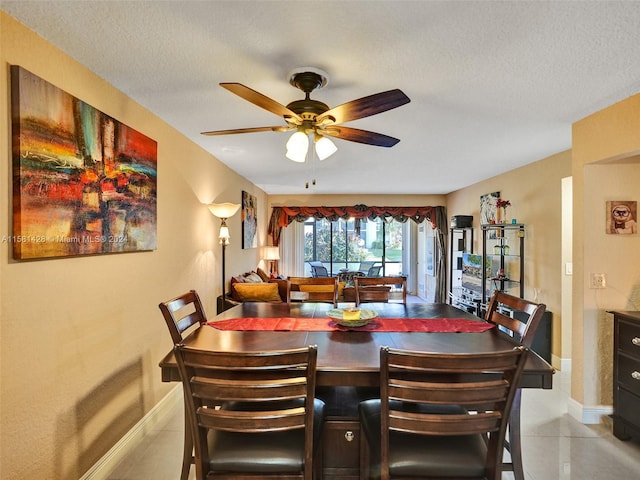 tiled dining space with ceiling fan and a textured ceiling