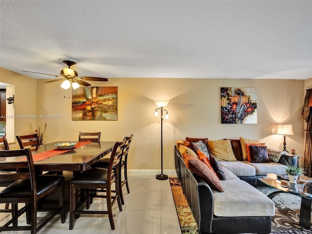 dining space with a textured ceiling, ceiling fan, and light tile floors