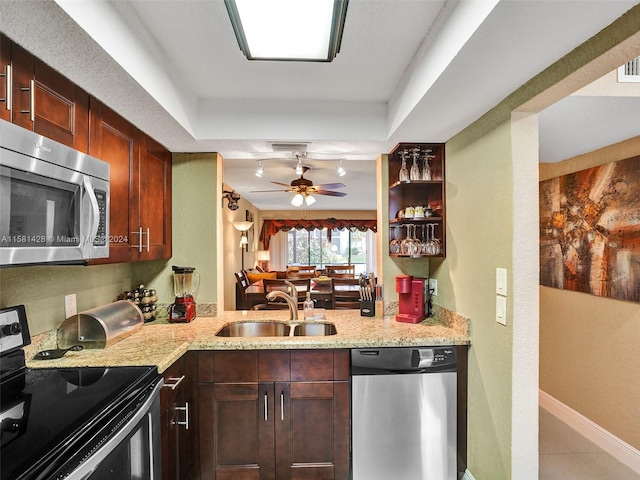 kitchen with stainless steel appliances, sink, ceiling fan, and a raised ceiling