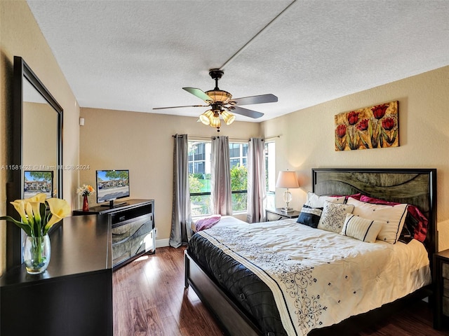 bedroom with dark wood-type flooring, ceiling fan, and a textured ceiling