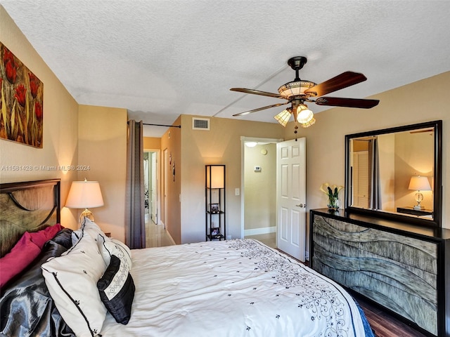 bedroom with ceiling fan and a textured ceiling