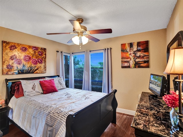 bedroom featuring dark wood-type flooring, ceiling fan, and a textured ceiling