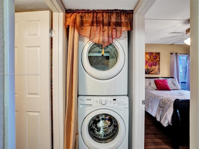 laundry area featuring dark wood-type flooring, stacked washer and dryer, and ceiling fan