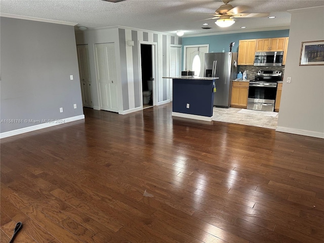 kitchen featuring ceiling fan, tasteful backsplash, dark hardwood / wood-style flooring, crown molding, and stainless steel appliances