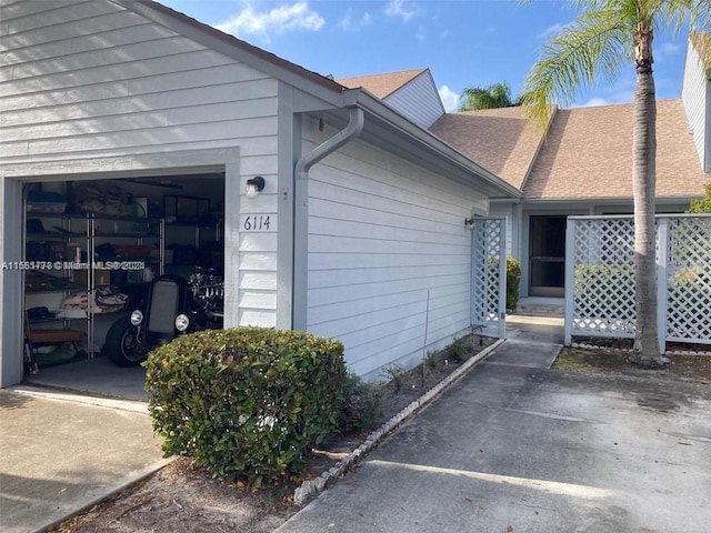 6114 SE Georgetown Pl, Hobe Sound, FL 33455 - view of side of property featuring a shingled roof and a garage