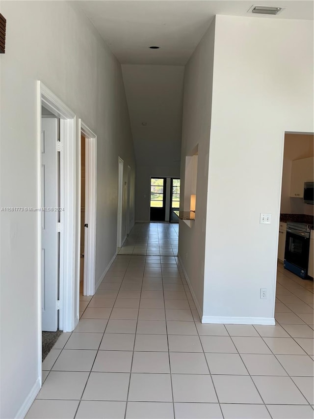 6114 SE Georgetown Pl, Hobe Sound, FL 33455 - hall featuring light tile patterned floors, baseboards, high vaulted ceiling, and visible vents
