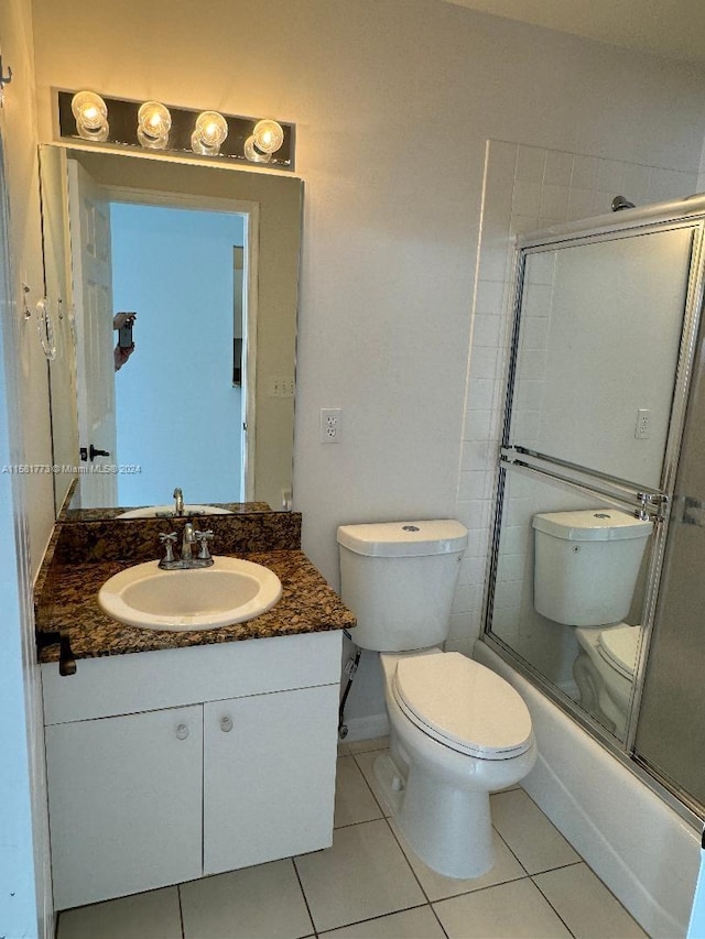 full bathroom featuring tile patterned floors, shower / bath combination with glass door, toilet, and vanity