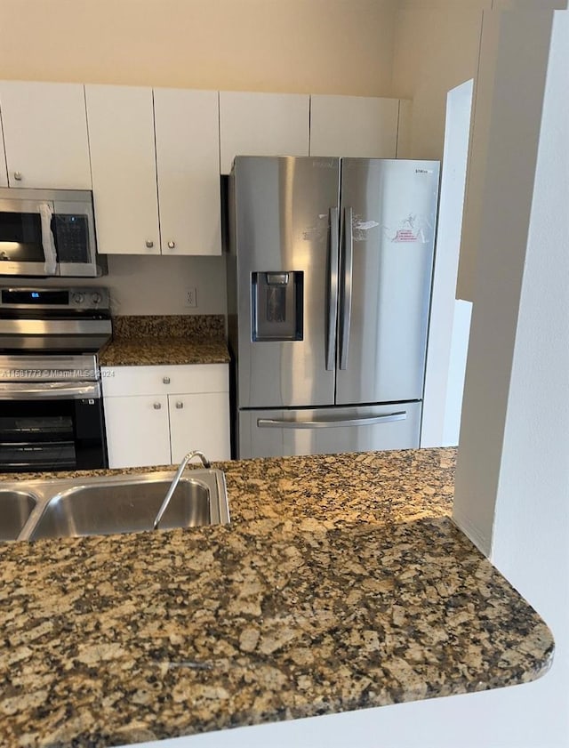 kitchen with white cabinetry, stainless steel appliances, and sink