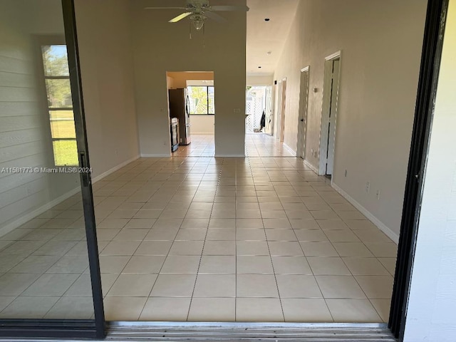 6114 SE Georgetown Pl, Hobe Sound, FL 33455 - spare room featuring baseboards, light tile patterned floors, a high ceiling, and a ceiling fan