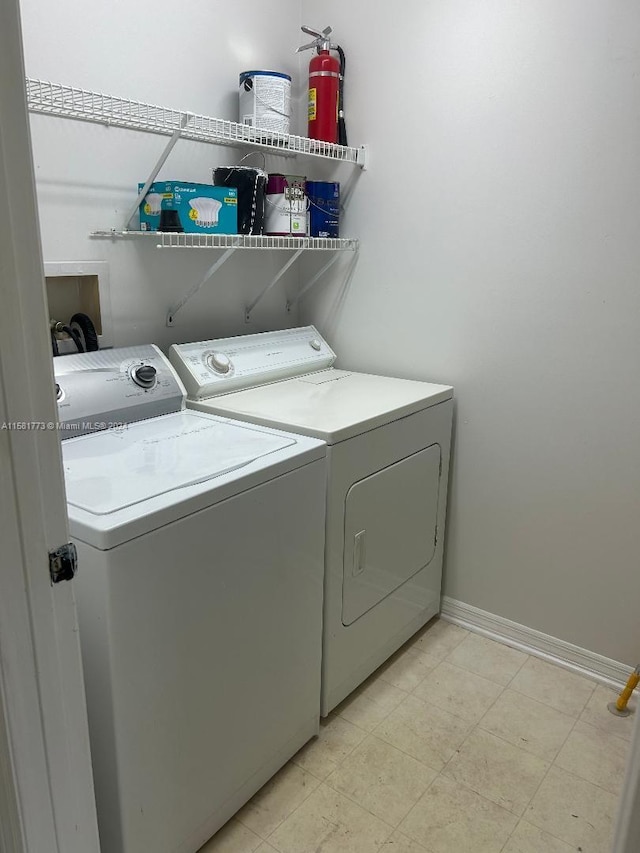 washroom with light tile patterned floors and washing machine and dryer