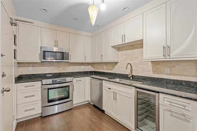 kitchen featuring hanging light fixtures, wine cooler, sink, dark hardwood / wood-style floors, and appliances with stainless steel finishes