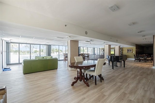 dining area with a wall of windows and light wood-type flooring