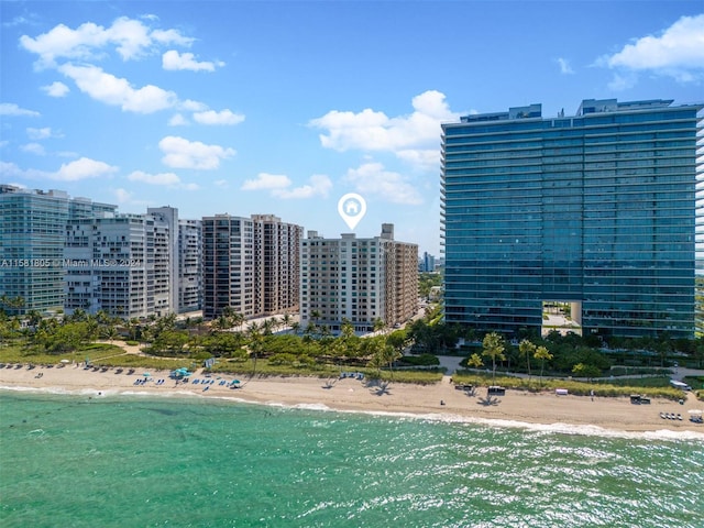 birds eye view of property featuring a water view and a beach view