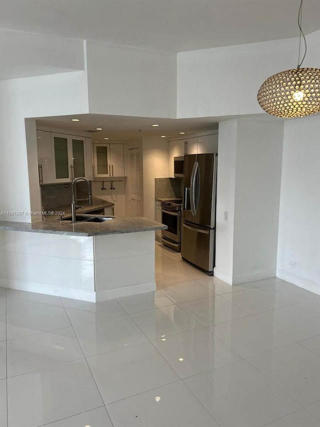 kitchen with appliances with stainless steel finishes, sink, kitchen peninsula, and light tile floors