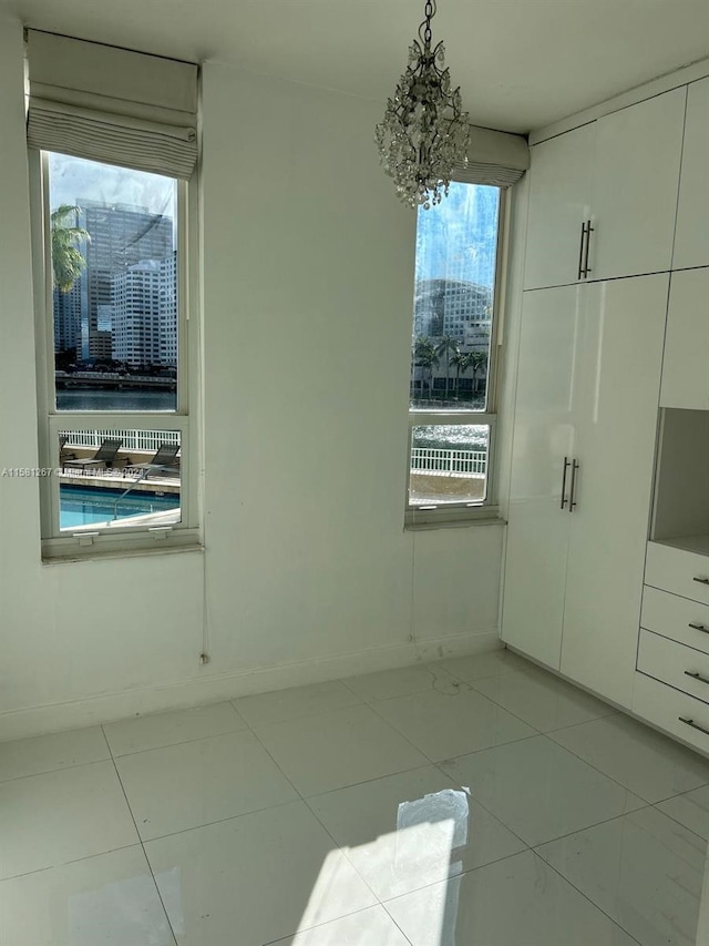 unfurnished bedroom featuring light tile floors and multiple windows