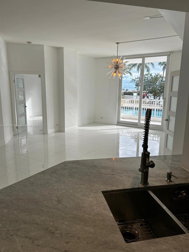 kitchen with an inviting chandelier, pendant lighting, light tile floors, and sink