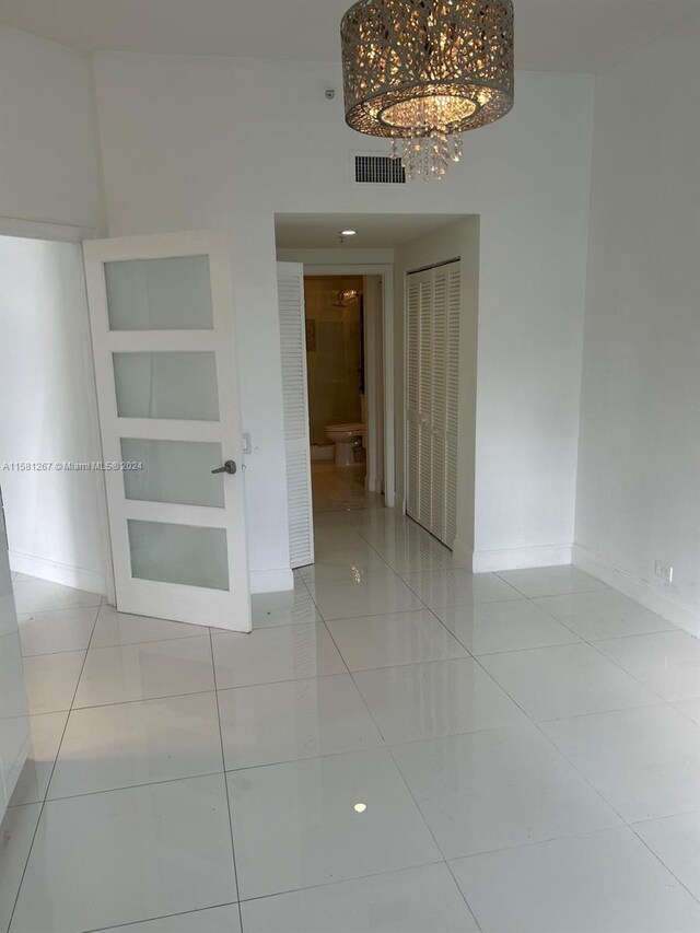 unfurnished room featuring a notable chandelier, light tile flooring, and built in features