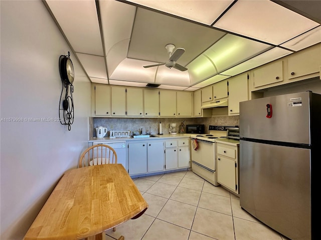 kitchen with backsplash, white appliances, ceiling fan, sink, and light tile floors