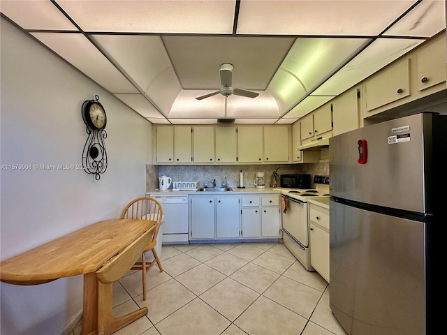 kitchen with white appliances, backsplash, sink, light tile floors, and ceiling fan