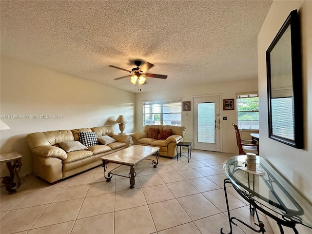 living room with ceiling fan, a textured ceiling, and light tile flooring