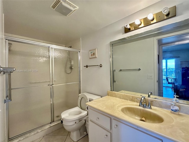 bathroom with an enclosed shower, vanity, tile floors, and toilet