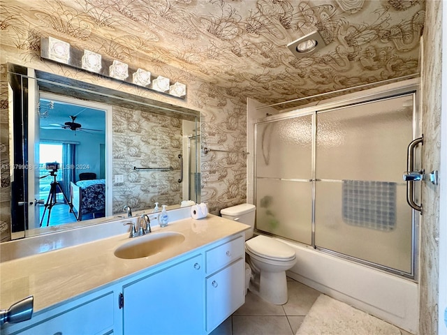 full bathroom featuring tile floors, vanity, shower / bath combination with glass door, toilet, and ceiling fan