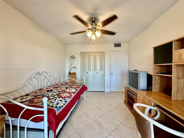 tiled bedroom featuring a closet, a textured ceiling, and ceiling fan