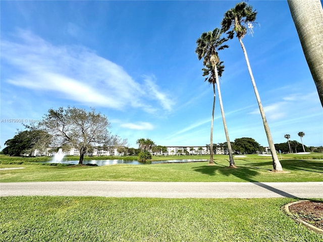 view of property's community with a water view and a yard