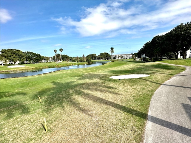 surrounding community featuring a water view and a lawn