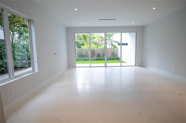 unfurnished room featuring a wealth of natural light and tile floors