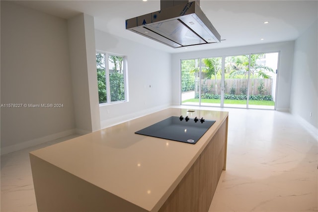 kitchen with a center island, a healthy amount of sunlight, and island range hood