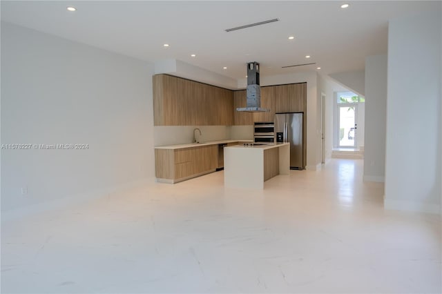 kitchen with appliances with stainless steel finishes, wall chimney range hood, sink, a center island, and light tile floors