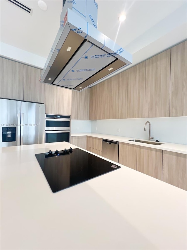 kitchen with sink, light brown cabinets, stainless steel appliances, and island range hood