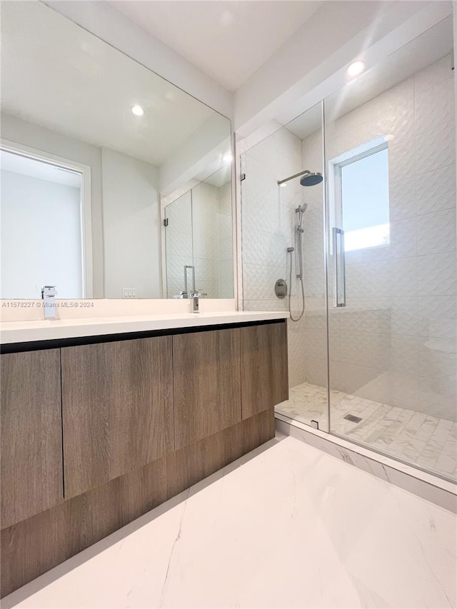 bathroom featuring tile floors, vanity, and a shower with door