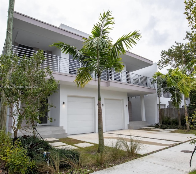 contemporary house featuring a garage and a balcony