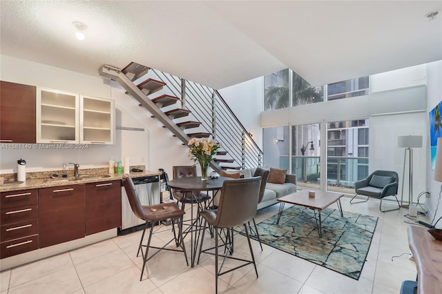 tiled dining area with a towering ceiling and sink