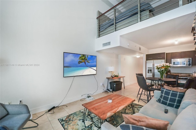 living room featuring a high ceiling and light tile floors