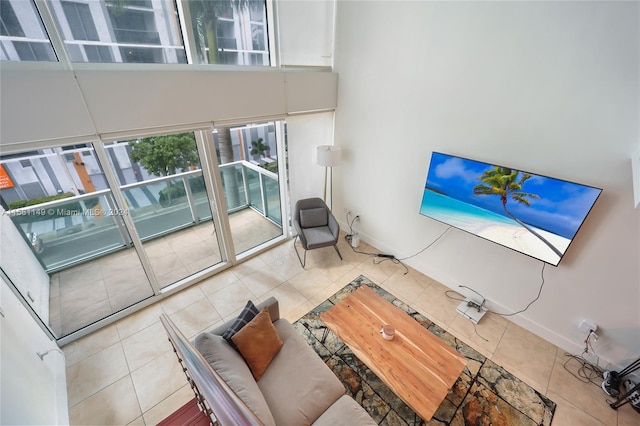 living room with a towering ceiling and light tile flooring